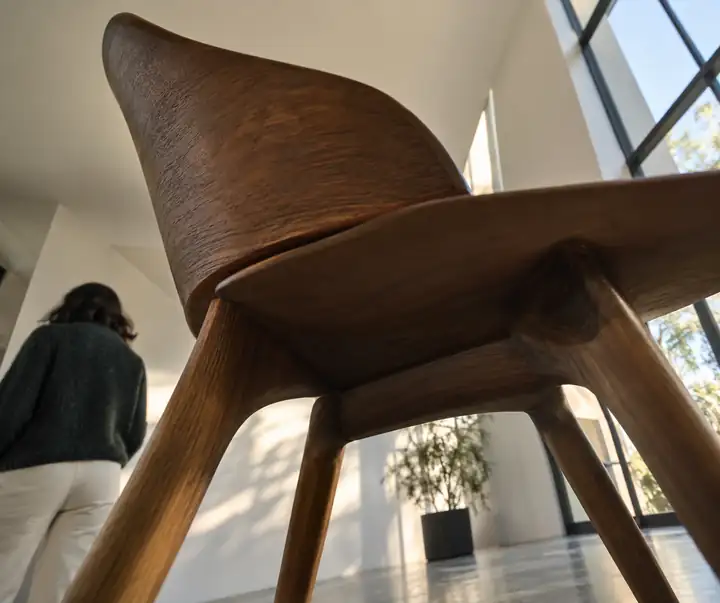 Ein Holzstuhl, aus einem extrem verzerrten Winkel fotografiert, der seine Struktur verdeckt.
